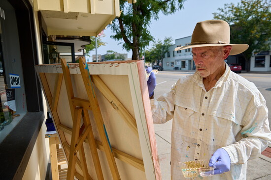 Artist Jim Klein paints in downtown Windsor, where private improvement grants help local businesses showcase their unique charm.