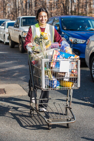Volunteer with a cart at Loaves and Fishes. Photo Credit: Scherer Joy Photography