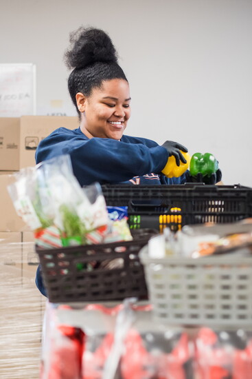 Working with produce at Loaves and Fishes. Photo Credit: Scherer Joy Photography