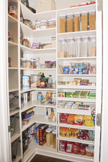 Taking shelving up higher and adding plexi-front sliding drawers and slanted can shelves all helped put essentials within easy reach in the pantry.