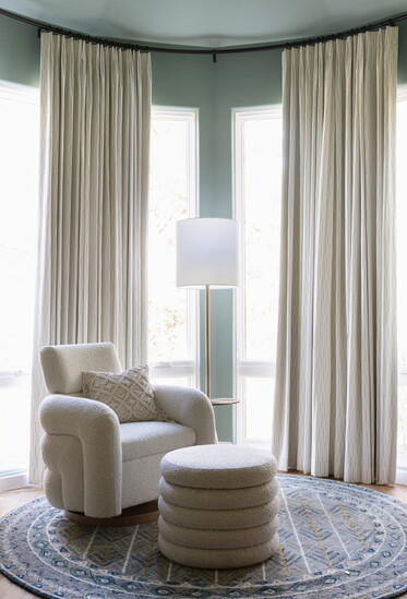 A stylish seating area enhanced by flowing drapery, adding texture and warmth to the space.