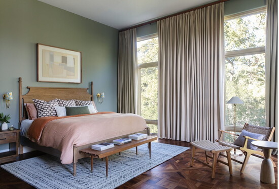 A serene bedroom retreat featuring warm mid-tone woods and calming green walls, designed for a peaceful night’s sleep.