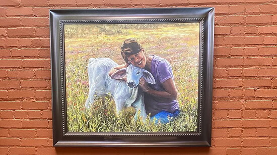 Judi Lanza, founder and director of The Art of Music Studio, beneath her award-winning painting.