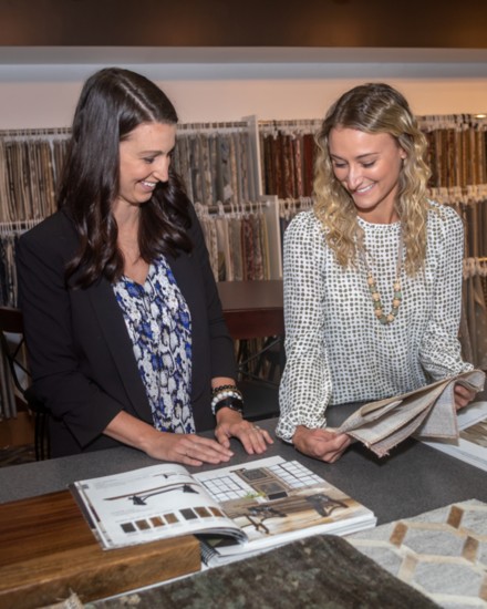 Julianne Goodwin and Caitlin Newman look through sample books in the B. F. Myers design center.