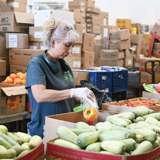 A Long Beach Community Table volunteer packages fresh produce at the organization’s warehouse.