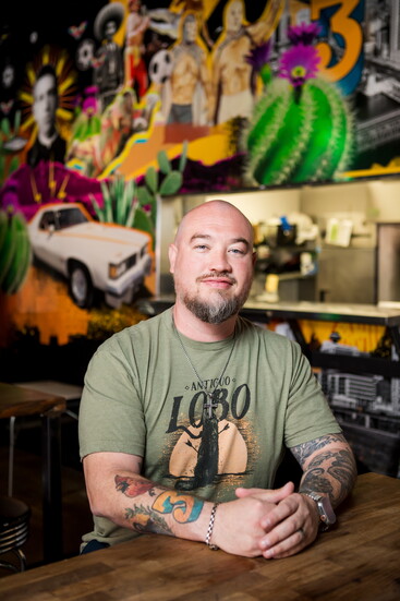 Jesús Orñate sits in his restaurant, Antiguo Lobo, in front of the mural dedicated to his father, Jesús Orñate Sr.