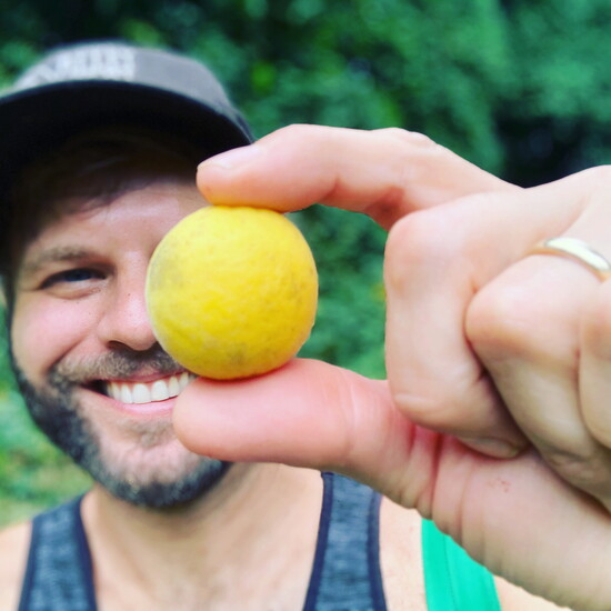 Micah LeMon holding a hardy orange. Photo Credit: Micah LeMon