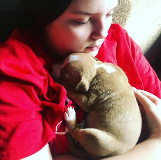 Nora Payton, 15, snuggles a foster puppy. Photo credit: Jennifer Payton.