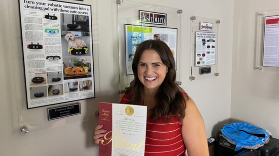 Francesca Holds Her Patent With Press Clippings in the Background