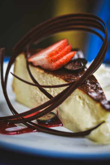 Traditional burnt cheesecake from the Basque region of Spain served with a raspberry sauce and tempered chocolate curls.