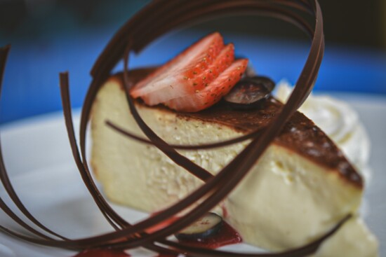 Traditional burnt cheesecake from the Basque region of Spain served with a raspberry sauce and tempered chocolate curls.