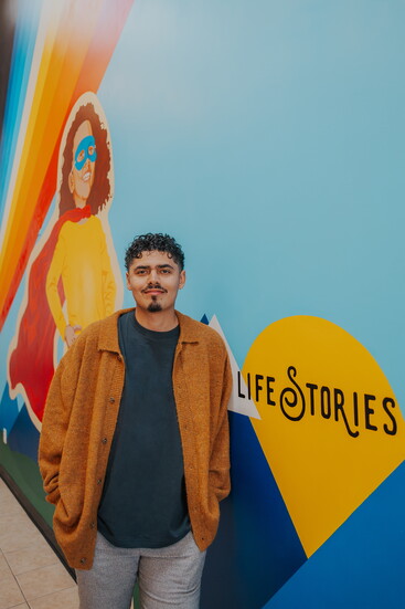 Artist Alonzo Harrison with his mural, Hope Starts at Life Stories, a powerful symbol of healing at Life Stories Child & Family Advocacy.
