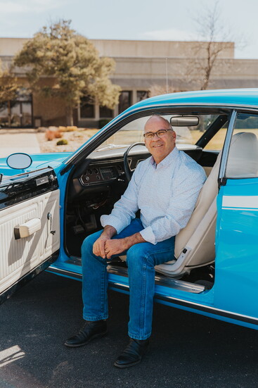 Dean takes a break with one of his pride and joys-a beautifully restored classic, reflecting his passion for craftsmanship both on the road and in real estate.