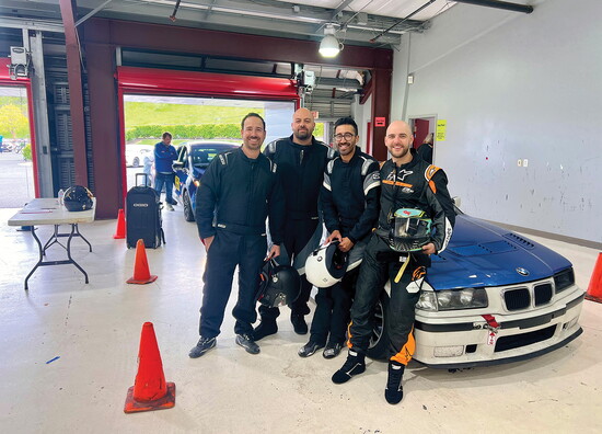 Rob Casares gears up with fellow drivers inside a garage before a race.