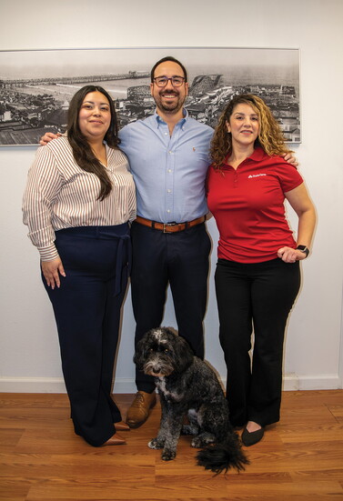 Team members gather inside the Long Beach office with Kevin, Rob Casares’ dog.