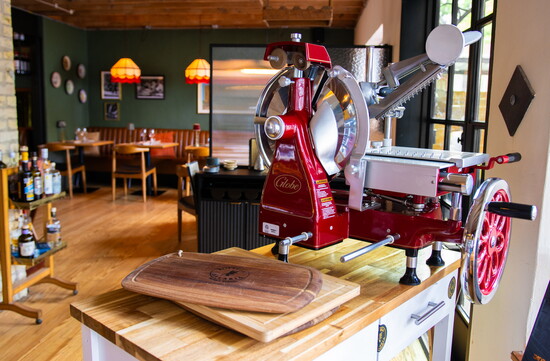 A vintage-style meat grinder hints at the hands-on preparation behind Bottega Salaria's kitchen, where tradition is part of the process. 