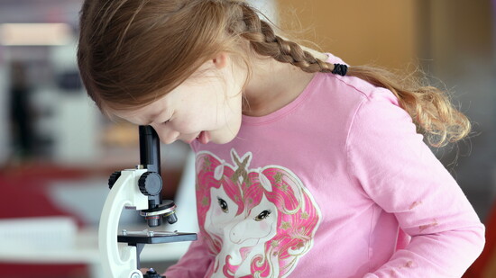 A child uses a microscope during a STEAM activity. (Photo provided)
