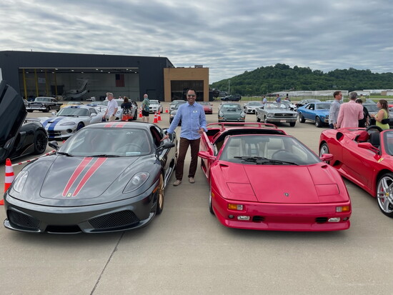 Benny with two rare cars at the Cincinnati Concours Hangar Party: his Ferrari 430 Scuderia (left) and a friend’s pink Lamborghini (right). 