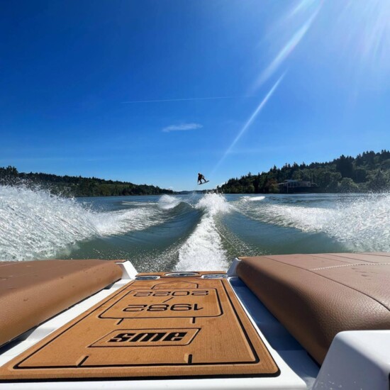 Drew Cardinale of AWS wakeboard jumping from wake to wake behind an AWS 40-year anniversary edition Malibu. 