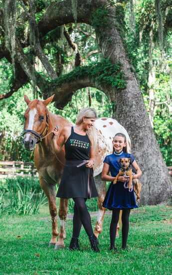 Gainesville Dance Academy Director Sarah Ingley with dancer Addison Griffin, palomino Jazz, and Irish terrier Orla.