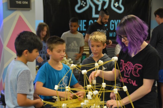 During camps at the Game Gym, groups compete in team-building activities like this one, where marshmallows and raw spaghetti serve as building materials.