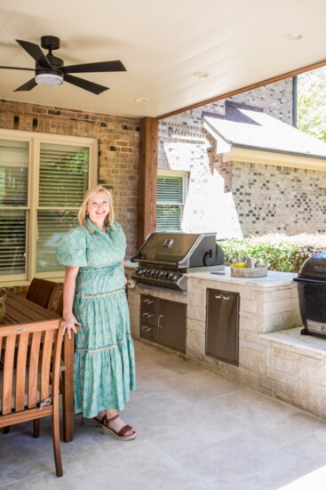 Jenny Ochotnicky, owner of JPO Interiors, stands in the grilling area of the outdoor patio and grilling area project.