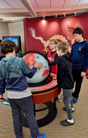 Young patrons explore the globe of dragon tales. Photo: Christopher Sikorski