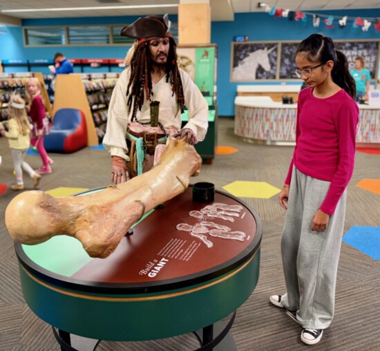 Costumed character Captain Jack Sparrow talks giants with a young patron. Photo: Jennifer Nickels.