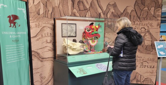 A patron views the display illustrating origins of myths regarding unicorns, griffins and giants.