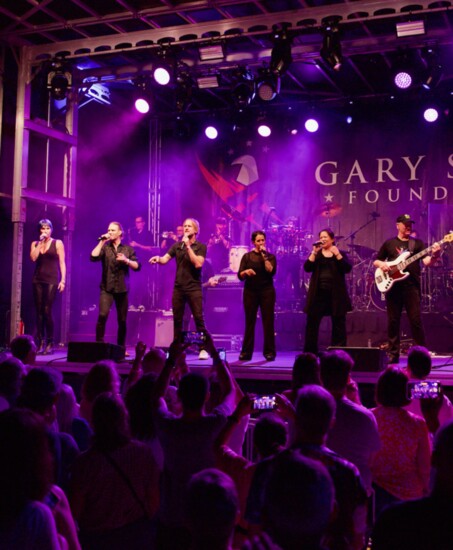 Gina (center) with the Lt. Dan Band performing in Highland Park for the Gary Sinise Foundation. Photo: Leo Heinz