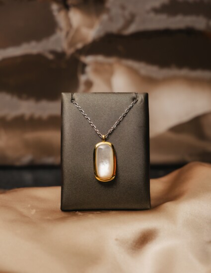 Give mom a beautiful Mother of Pearl pendant set in a yellow gold plated pendant with a Rhodium cable chain. 