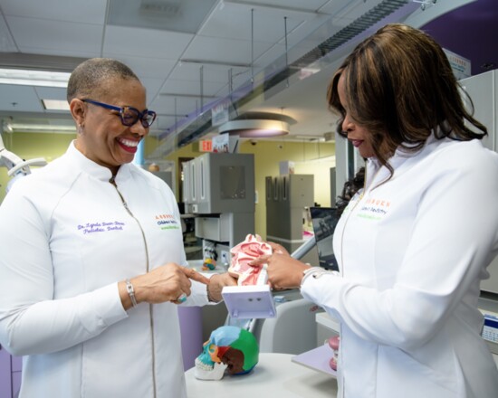 Drs. Lynda and Krystle Dean-Duru use a moveable head and jaw to explain their treatment plans with children.