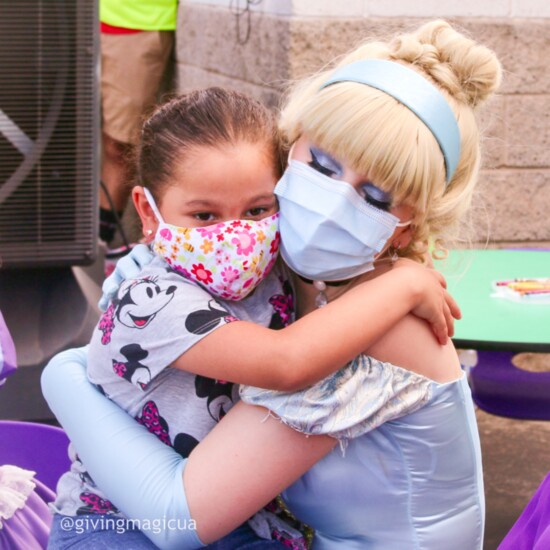 Cinderella hugs a child at St. Vincent de Paul’s summer event.