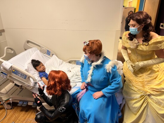 Black Widow, Anna, and Belle cheer up a sick child.