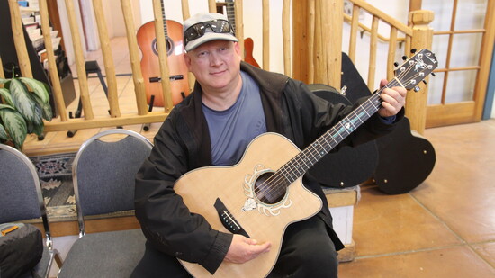 Daniel Patron and his new custom Pimentel auditorium acoustic guitar. Note the turquoise Zia.