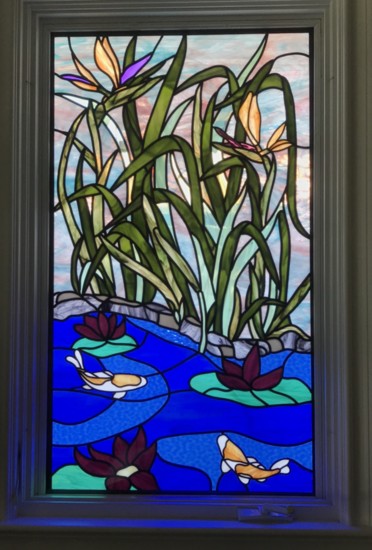 This glass art piece replaced an unattractive view of a neighbor's house with a beautiful stained glass koi pond.