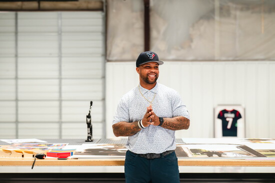 A selection of framed sports memorabilia highlights Quin’s transition from Houston Texans standout to business owner.