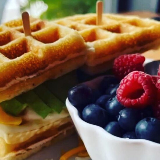 Enjoy a gluten-free waffle sandwich stuffed with fried eggs, avocado and cheese at Re:Bar Cafe.