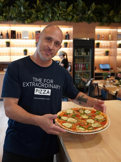 Chef Miguel Blatt holds an example of the delicious pizzas served at Mister O1 Extraordinary Pizza. Photo Provided by Mister O1 Extraordinary Pizza