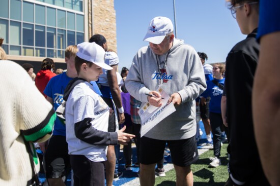 Coach Kevin Wilson signs his autograph for a young man at the Tulsa Football Springfest. Photo provided.