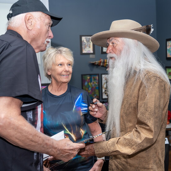 William Lee Golden autographs a copy of his new book for two fans.