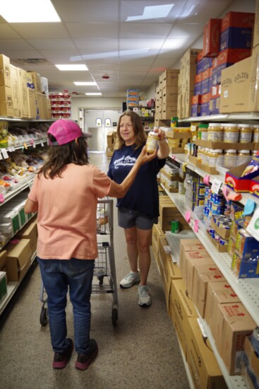 Market Depot staff assists a client with groceries.