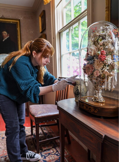 Collections Manager Molly Liolios dusting off a commemorative pitcher at the John Paul Jones House, Photo courtesy of Sabina Ion