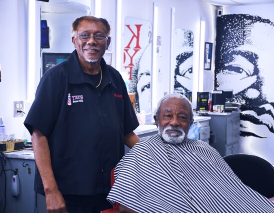 Tee's Barber Shop, since 1985, is a place to get a haircut and have a chat. Pictured are barber Willie Sells and customer Henry Ellis. Photo by Nancy Hermann.
