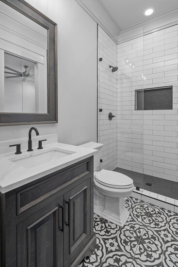 Bold Meets Classic: A vintage-inspired tile pairs beautifully with sleek subway walls and a frameless glass shower for timeless impact.
