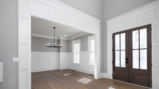 Warm Welcome: Wide plank hardwoods in matte oak tones create an inviting, grounded feel in this stunning front entry.