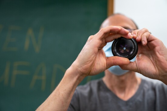 Photography teacher Mazen Abufadil looks through a lens. 