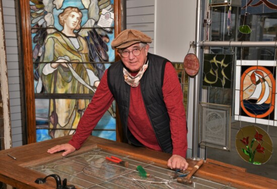 Richard Bohm works on a stained glass door.