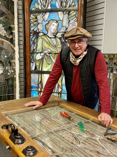 Richard Bohm works on a stained glass door.