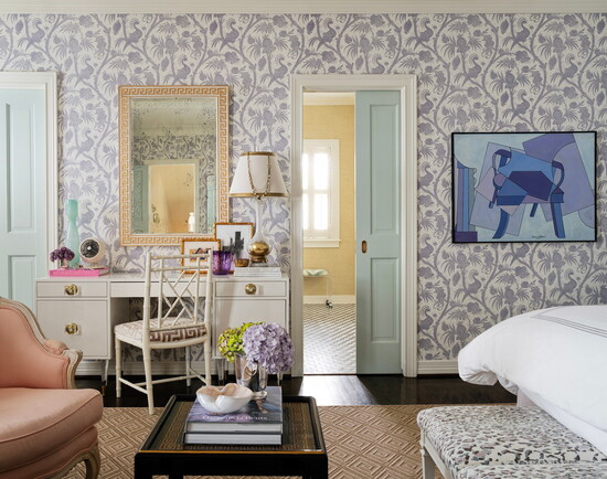 Wallpaper in soft purple tones envelops this primary bedroom.